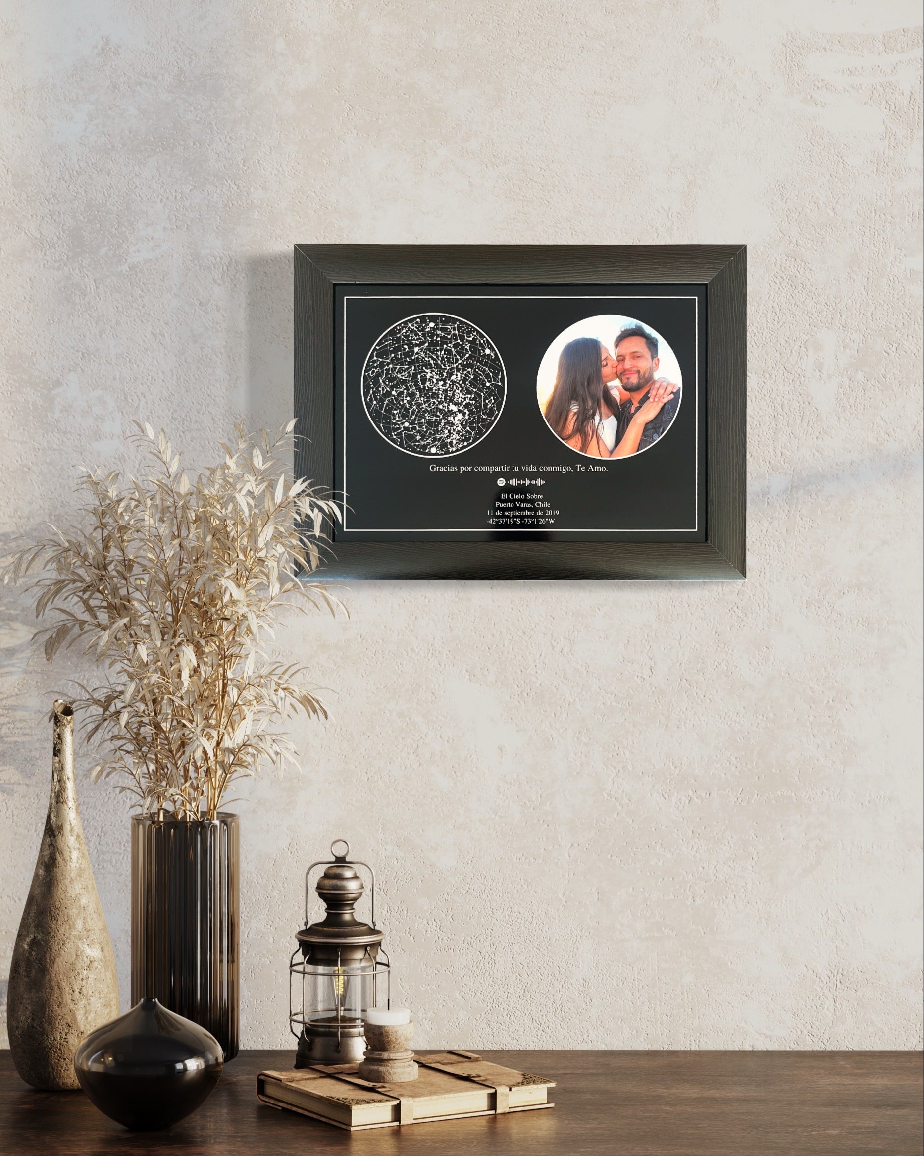 Cuadro “Mapa Estelar Cielo Foto” en formato horizontal, con mapa de estrellas y foto de pareja, colgado en pared sobre mesa decorativa.