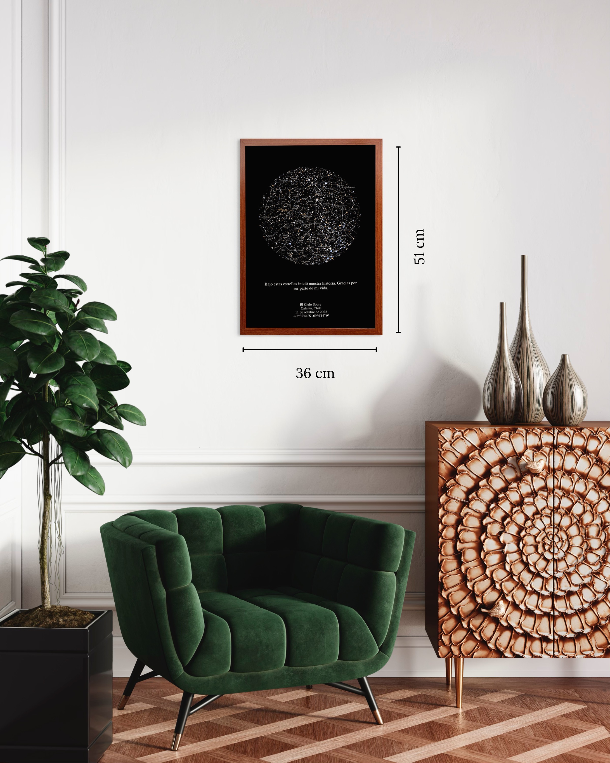 Mapa estelar XL enmarcado con medidas 36 x 51 cm sobre pared blanca junto a sillón verde y mueble de madera tallada