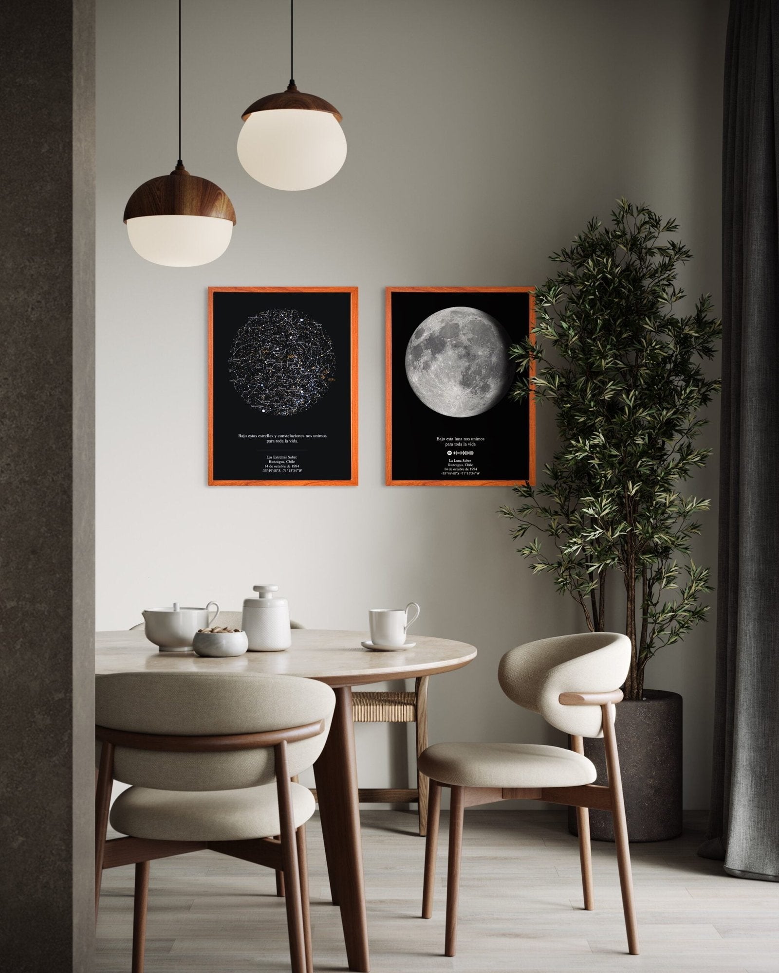 Cuadro decorativo con mapa estelar y mapa lunar enmarcados, colgados sobre un comedor moderno con mesa redonda y sillas de madera.