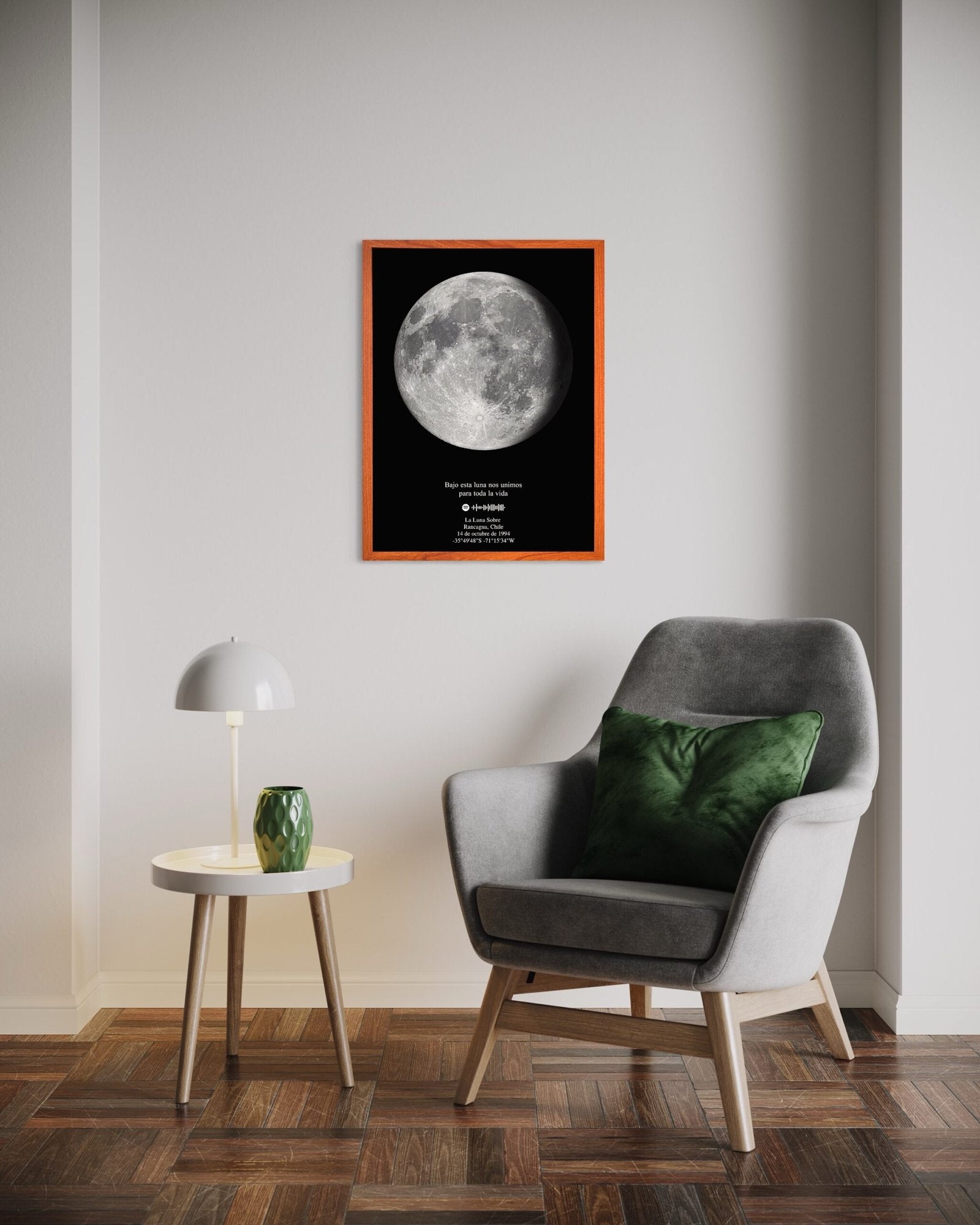 Mapa lunar XL con marco color madera colgado sobre un rincón de lectura con sillón gris y cojín verde, ideal para decorar espacios modernos.