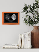 Mapa estelar con la fase lunar exacta de una fecha especial, enmarcado en café sobre mesa decorativa de estilo moderno