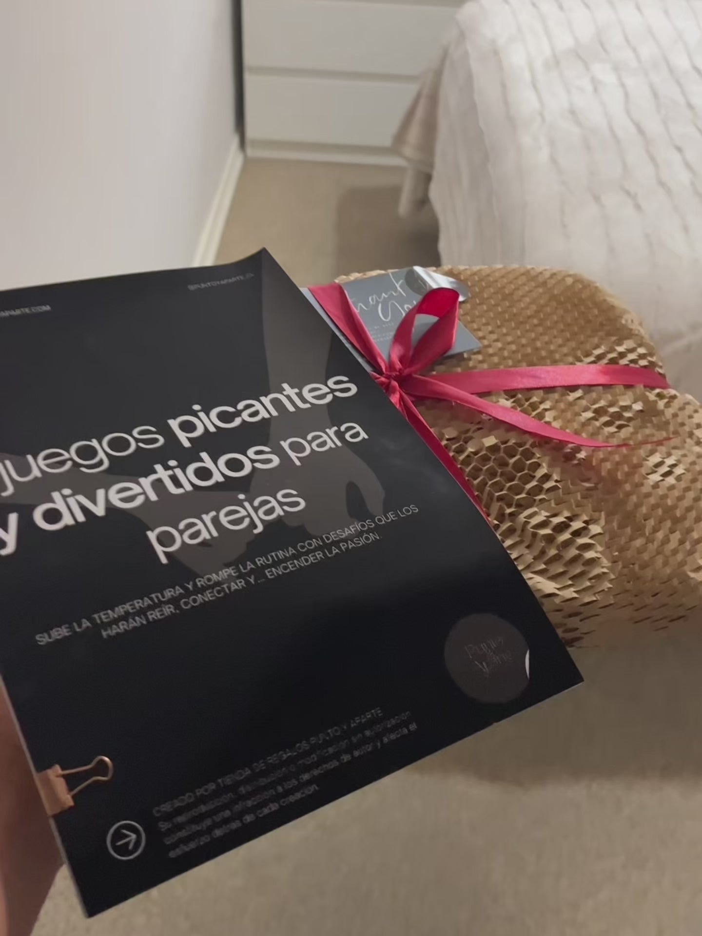 Video de la revista 5 juegos picantes para parejas, envuelta en papel panal con cinta roja, lista para regalar.